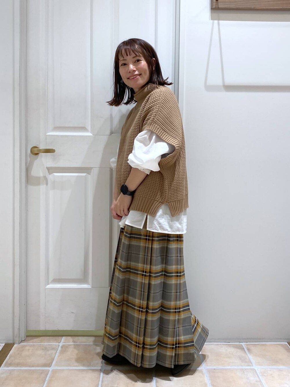 ブラック系のブーツ、ブラウン系のベスト、ホワイト系のシャツ/ブラウスを着用したレディースの秋コーディネートの4枚目の写真