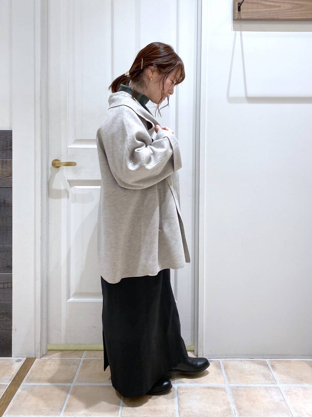 ブラック系のスカート、グレー系のテーラードジャケット、ブラック系のブーツを着用したレディースの秋コーディネートの4枚目の写真