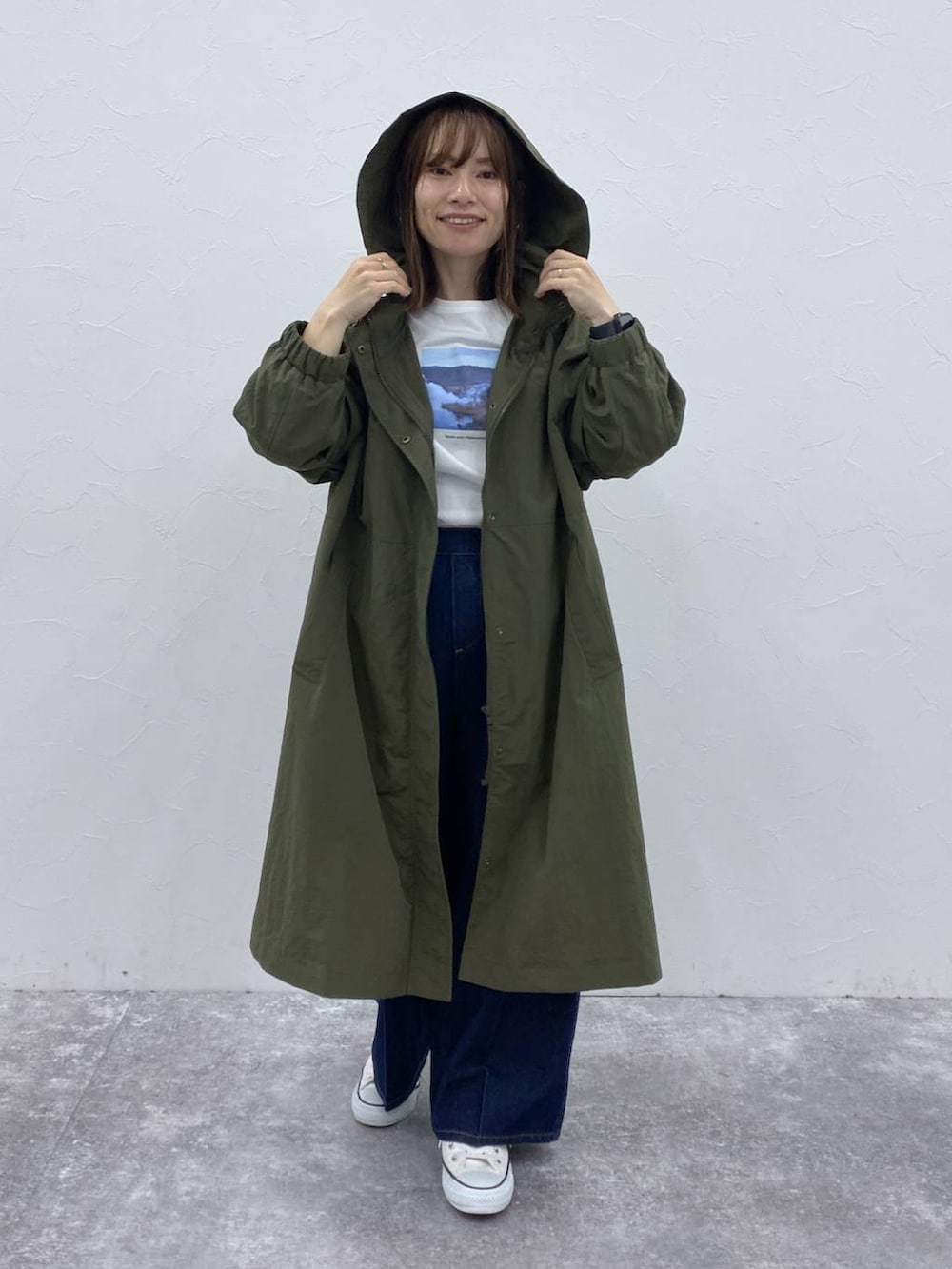 ブルー系のデニムパンツ、グリーン系のその他アウター、その他のTシャツ/カットソーを着用したレディースの秋コーディネートの3枚目の写真