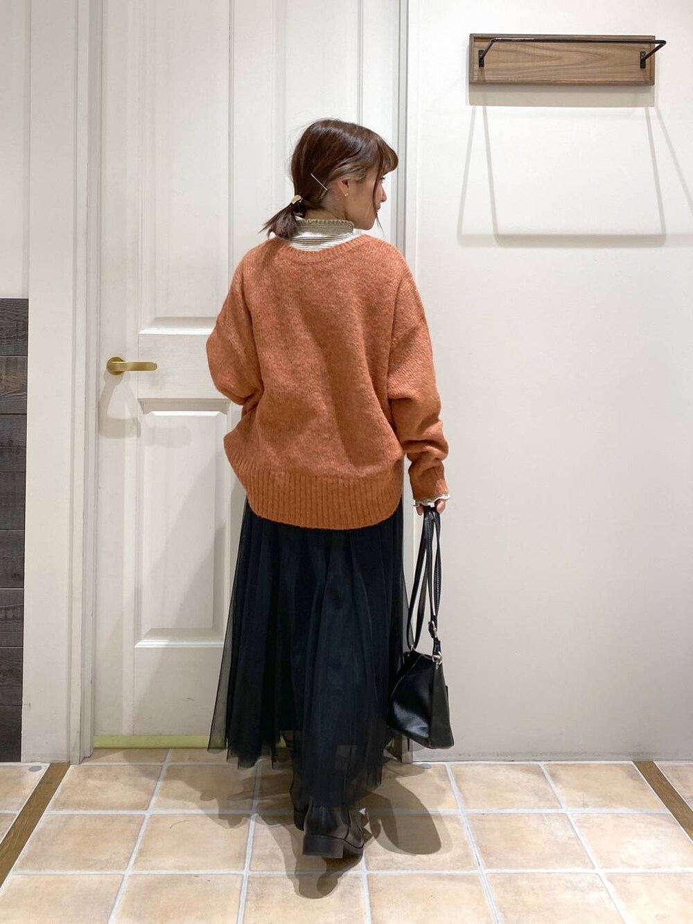 その他のTシャツ/カットソー、ブラック系のブーツ、オレンジ系のニット/セーターを着用したレディースの冬コーディネートの6枚目の写真