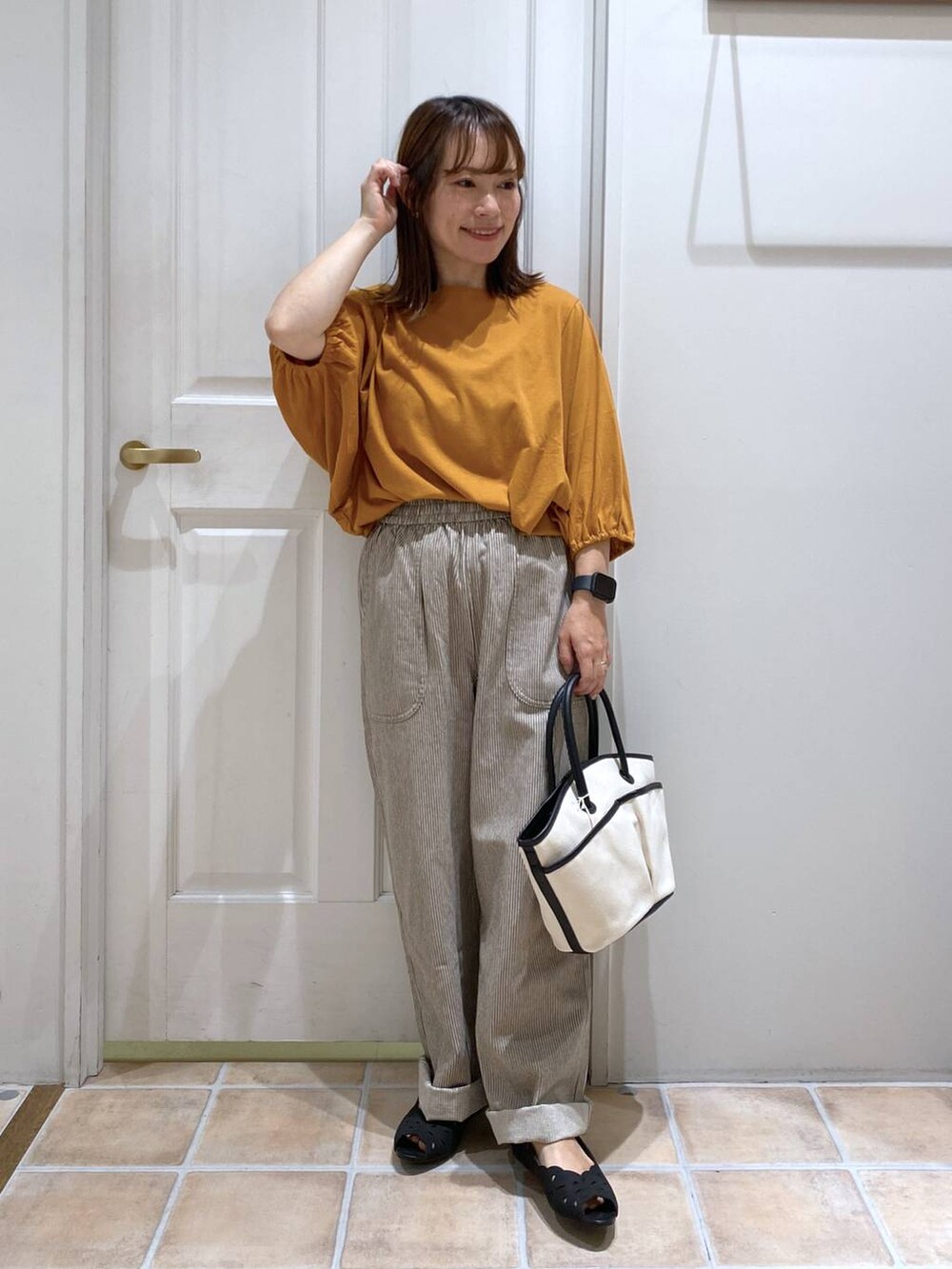 オレンジ系のTシャツ/カットソー、ブラック系のキャミソール、その他のデニムパンツを着用したレディースの夏コーディネートの2枚目の写真