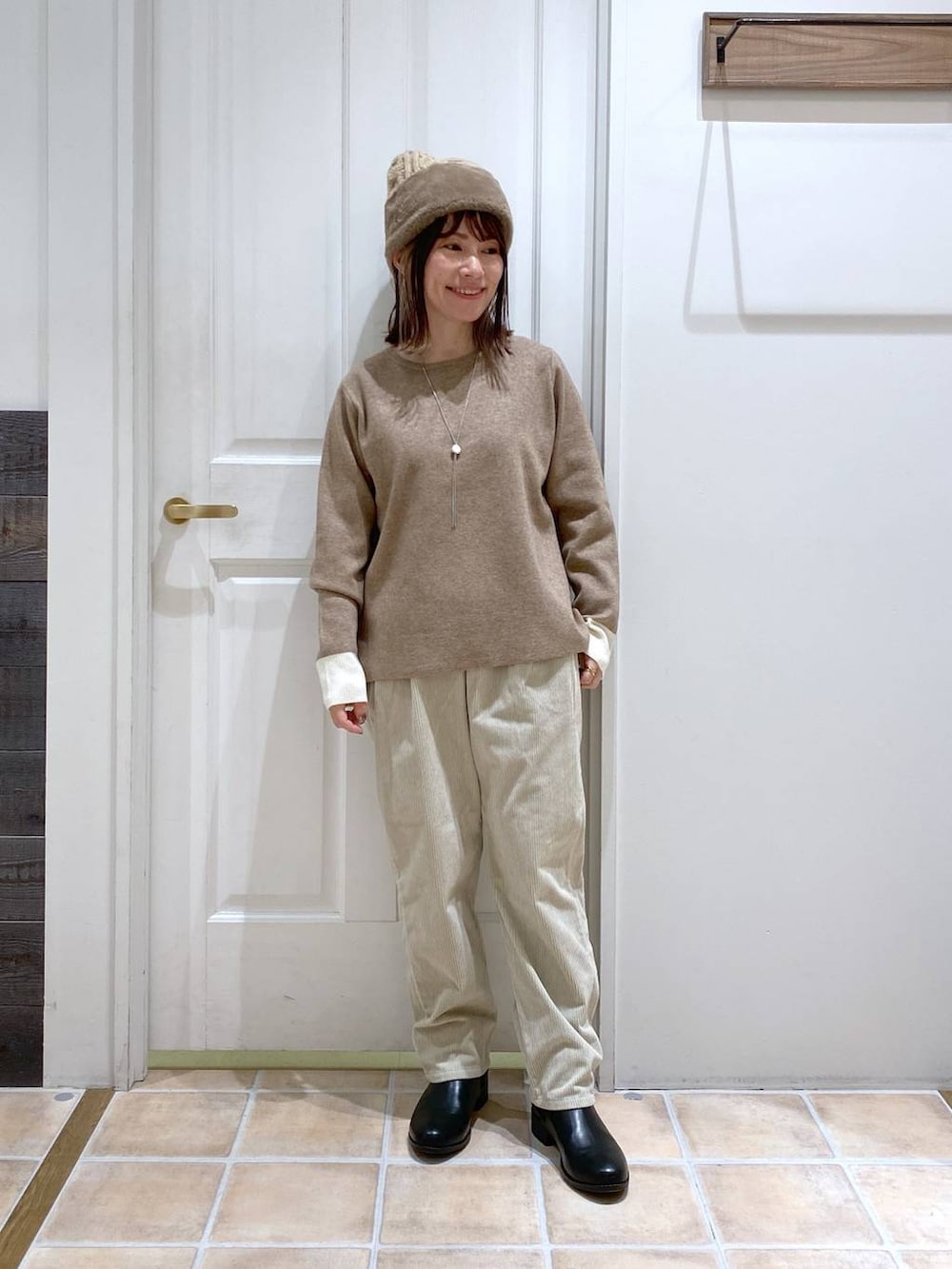 ブラック系のブーツ、グレー系のその他パンツ、ブラウン系のニット/セーターを着用したレディースの冬コーディネートの2枚目の写真