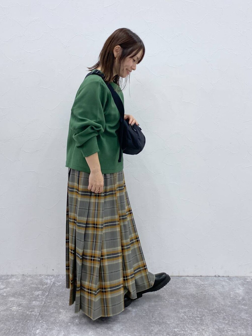 ブラック系のブーツ、ブラック系のショルダーバッグ、その他のスカートを着用したレディースの秋コーディネートの6枚目の写真