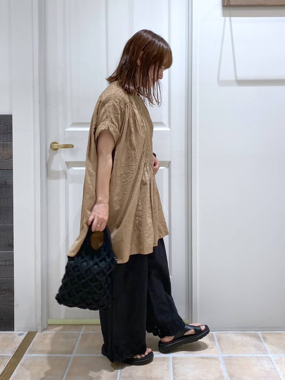 ブラウン系のタンクトップ、ブラック系のその他パンツ、ブラック系のサンダルを着用したレディースの夏コーディネートの5枚目の写真