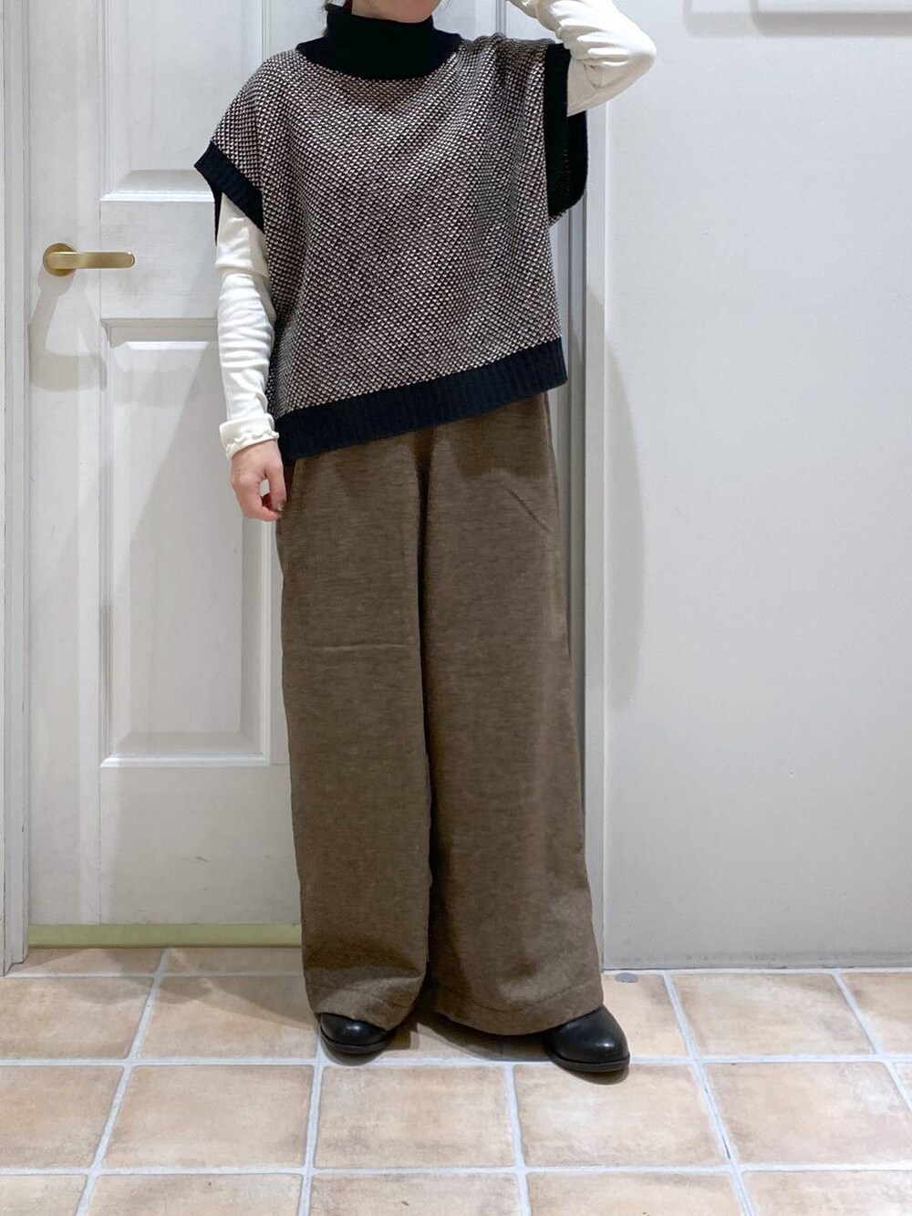 ホワイト系のTシャツ/カットソー、ブラック系のブーツ、ブラック系のベストを着用したレディースの秋コーディネートの2枚目の写真