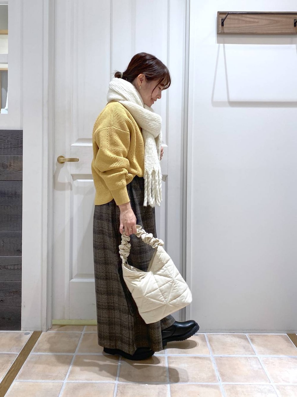 イエロー系のニット/セーター、その他のその他パンツ、ベージュ系のトートバッグを着用したレディースの秋コーディネートの4枚目の写真