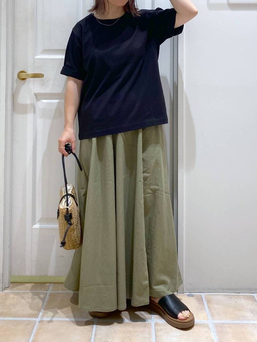 ブラウン系のショルダーバッグ、ブラック系のTシャツ/カットソー、ブラック系のサンダルを着用したレディースの夏コーディネートの2枚目の写真