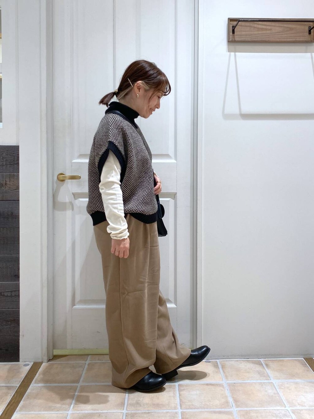 ホワイト系のTシャツ/カットソー、ブラック系のブーツ、ブラック系のベストを着用したレディースの冬コーディネートの5枚目の写真