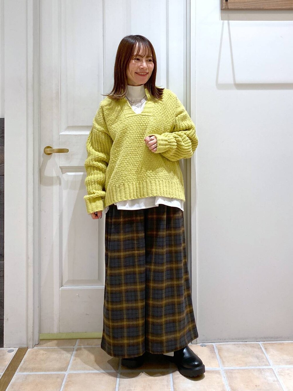 イエロー系のその他パンツ、ブラック系のブーツ、ホワイト系のシャツ/ブラウスを着用したレディースの冬コーディネートの2枚目の写真