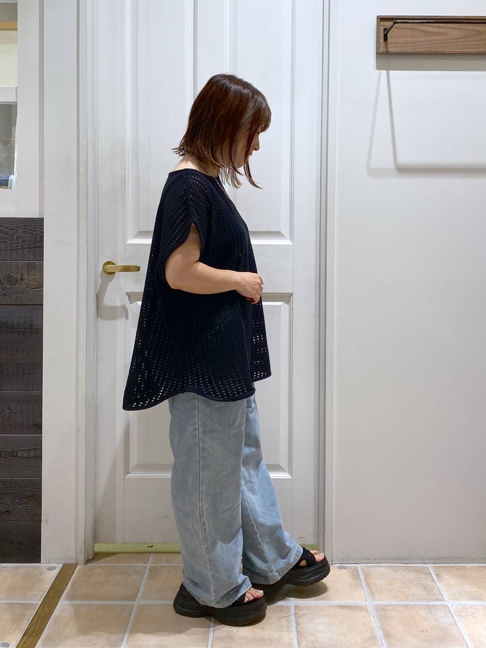 ブラック系のサンダル、ブルー系のデニムパンツ、ブラック系のTシャツ/カットソーを着用したレディースの夏コーディネートの4枚目の写真