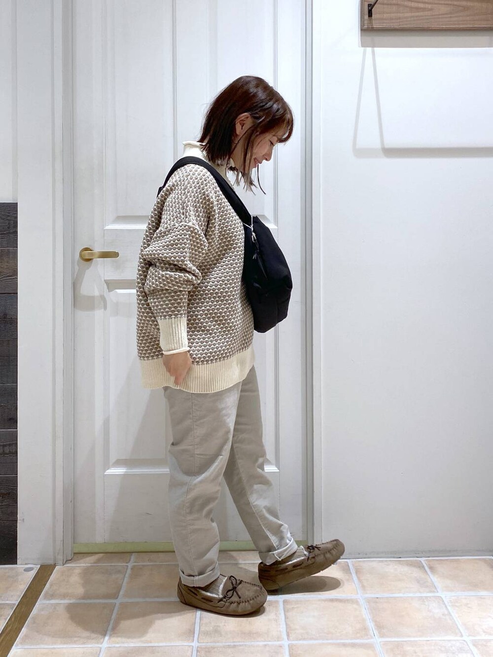 グレー系のその他パンツ、ホワイト系のニット/セーター、グレー系のモカシン/デッキシューズを着用したレディースの秋コーディネートの3枚目の写真