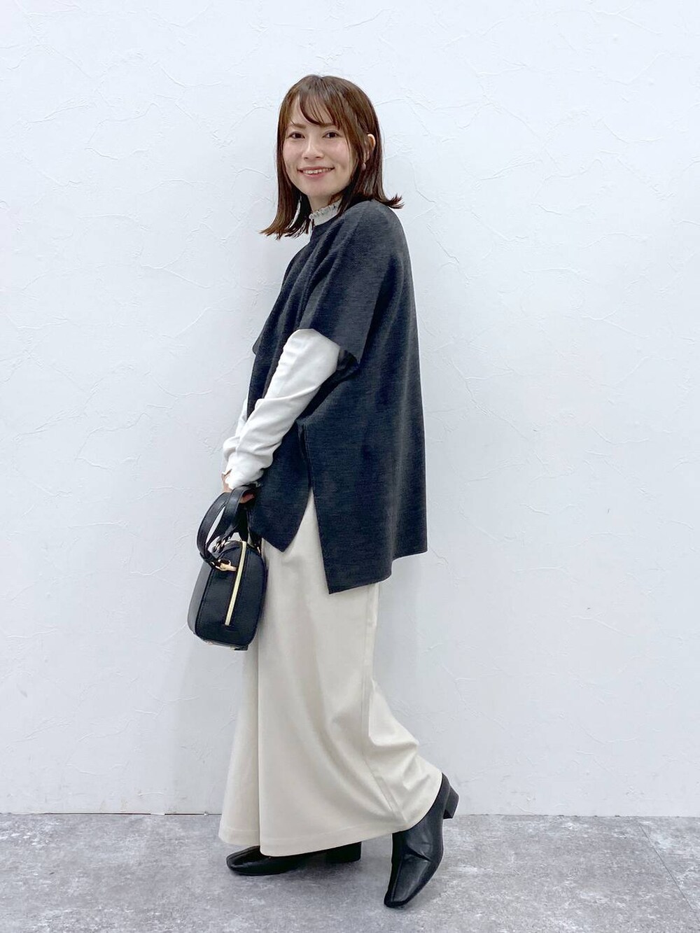 グレー系のTシャツ/カットソー、ブラック系のブーツ、ベージュ系のその他パンツを着用したレディースの冬コーディネートの5枚目の写真