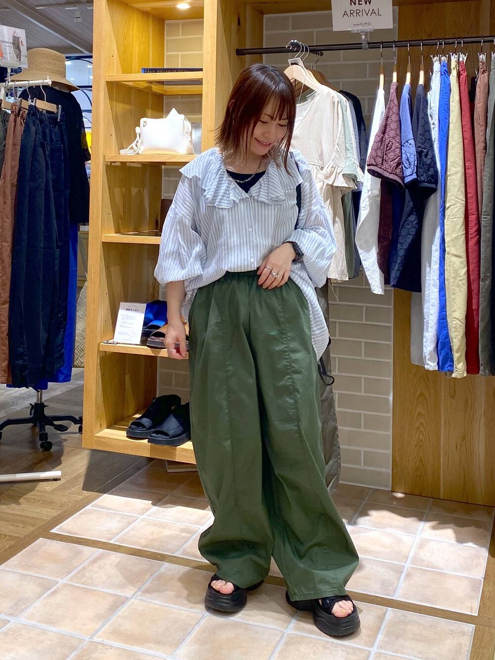 ブラック系のサンダル、グリーン系のその他パンツ、ブラック系のショルダーバッグを着用したレディースの夏コーディネートの2枚目の写真