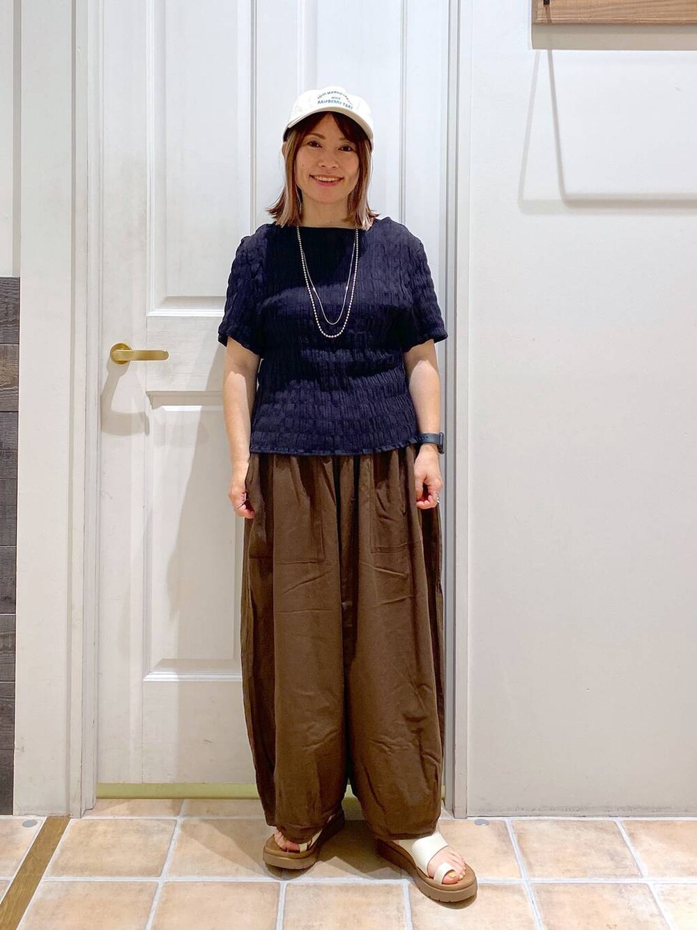 ベージュ系のサンダル、ブラウン系のその他パンツ、ブラック系のシャツ/ブラウスを着用したレディースの夏コーディネートの3枚目の写真