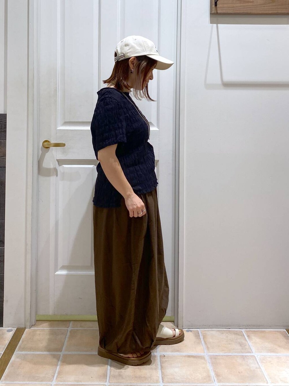 ベージュ系のサンダル、ブラウン系のその他パンツ、ブラック系のシャツ/ブラウスを着用したレディースの夏コーディネートの4枚目の写真