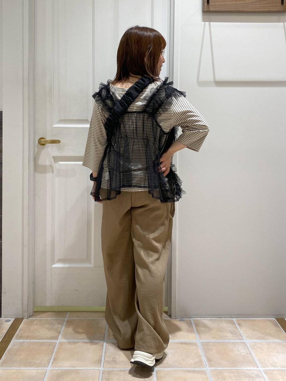 その他のTシャツ/カットソー、ブラック系のショルダーバッグ、ブラック系のスニーカーを着用したレディースの秋コーディネートの5枚目の写真