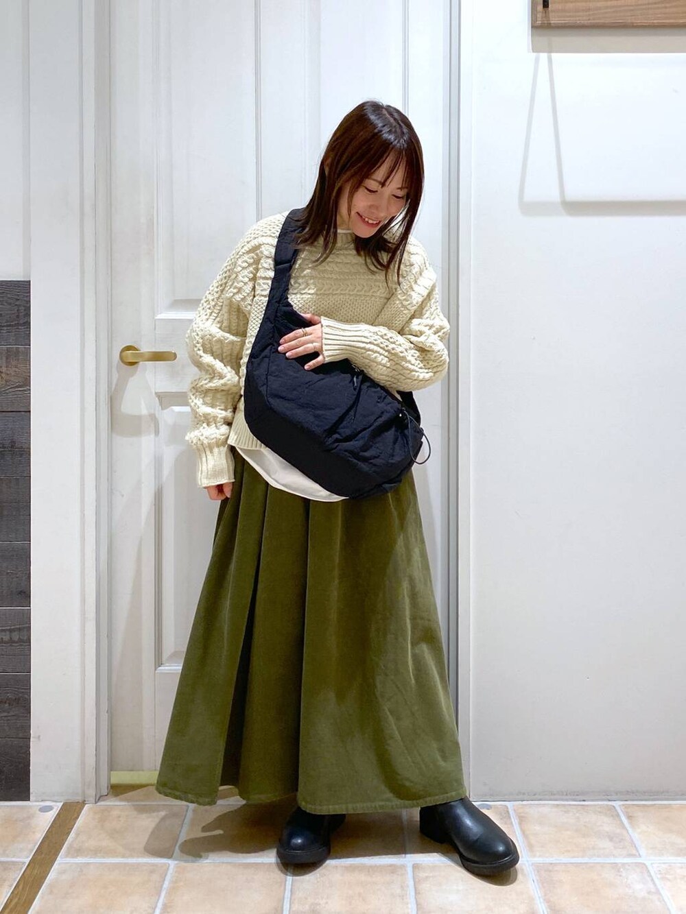 グリーン系のその他パンツ、ブラック系のブーツ、ブラック系のショルダーバッグを着用したレディースの冬コーディネートの4枚目の写真