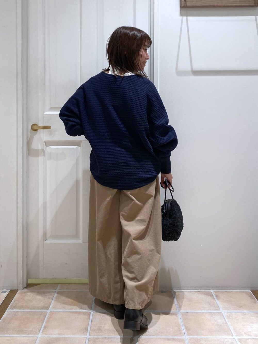 ベージュ系のその他パンツ、ブラック系のブーツ、ブルー系のニット/セーターを着用したレディースの秋コーディネートの7枚目の写真