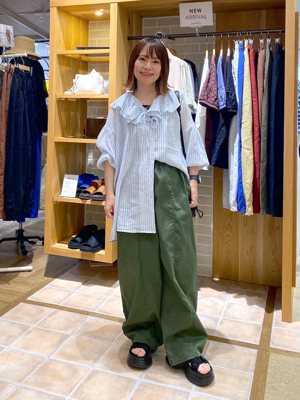 ブラック系のサンダル、グリーン系のその他パンツ、ブラック系のショルダーバッグを着用したレディースの夏コーディネートの4枚目の写真