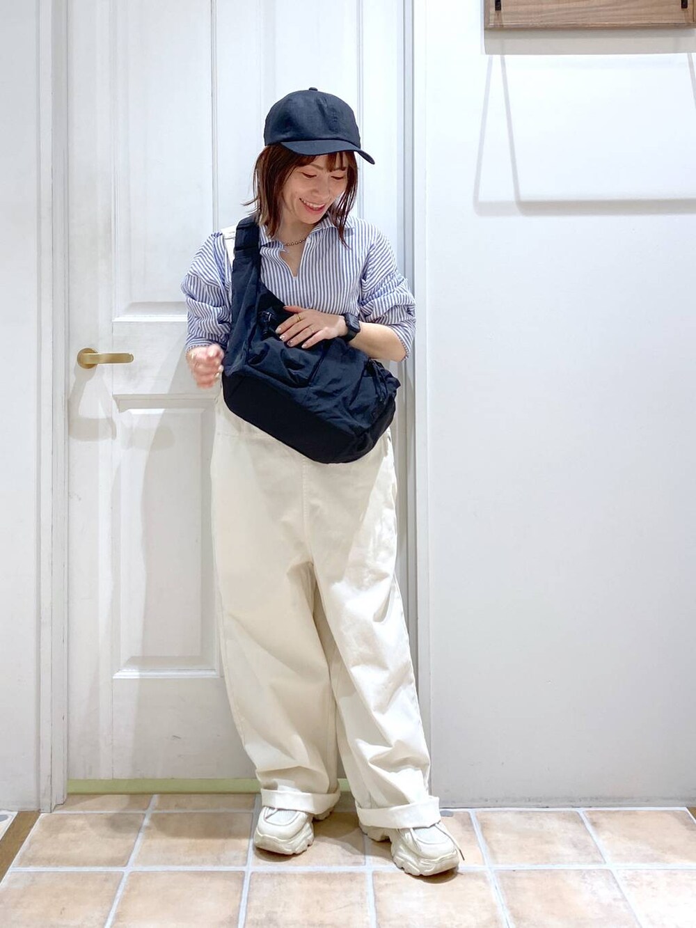 ブラック系のショルダーバッグ、その他のシャツ/ブラウス、ホワイト系のスニーカーを着用したレディースの春コーディネートの3枚目の写真