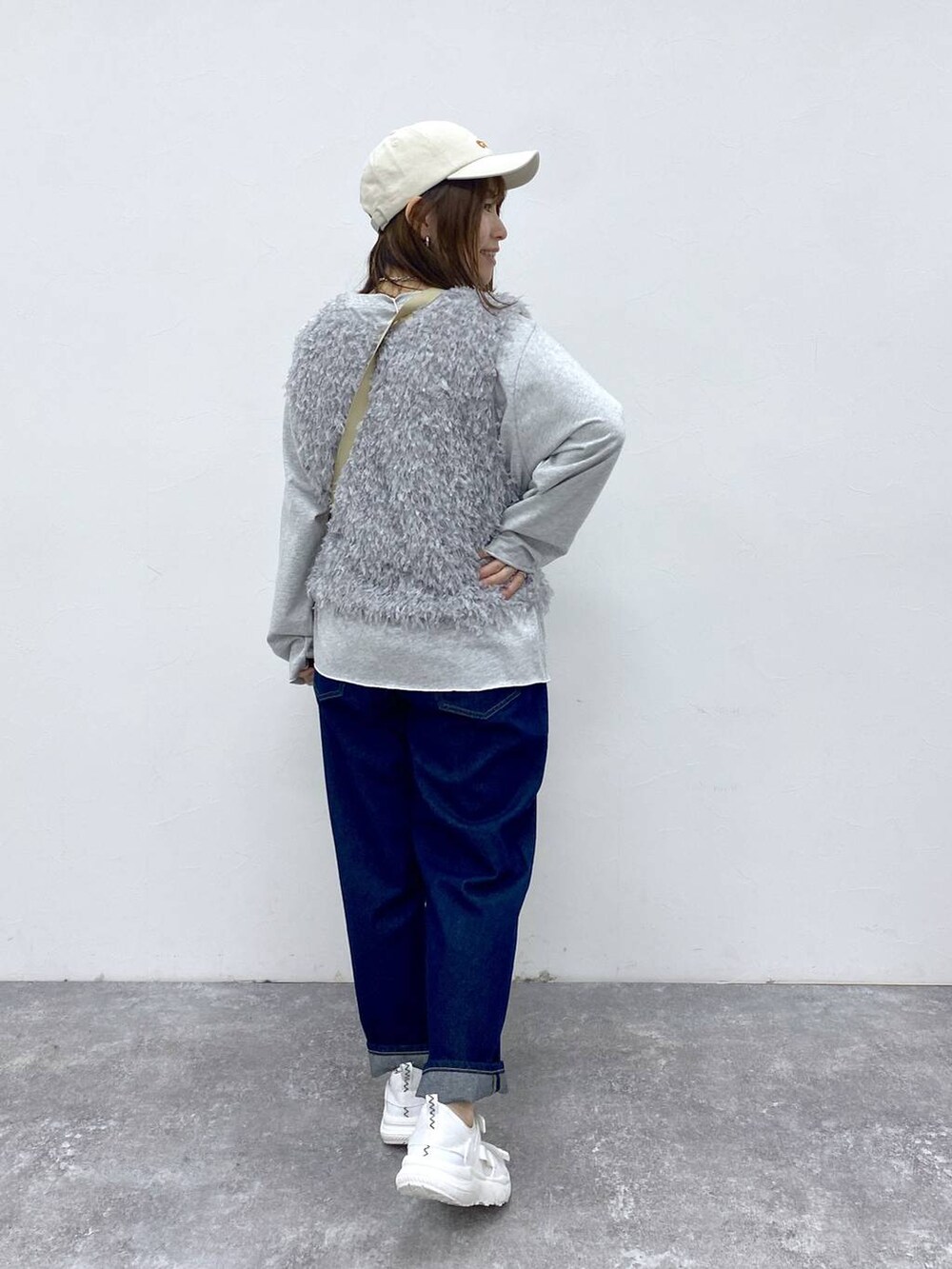 ブルー系のデニムパンツ、グレー系のベスト、グレー系のTシャツ/カットソーを着用したレディースの春コーディネートの4枚目の写真