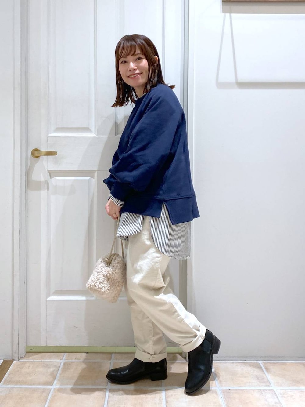 ブルー系のスウェット、ホワイト系のその他パンツ、ブラック系のブーツを着用したレディースの秋コーディネートの4枚目の写真