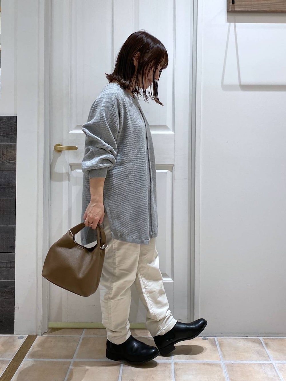 ホワイト系のその他パンツ、ブラック系のブーツ、ブラウン系のショルダーバッグを着用したレディースの秋コーディネートの5枚目の写真