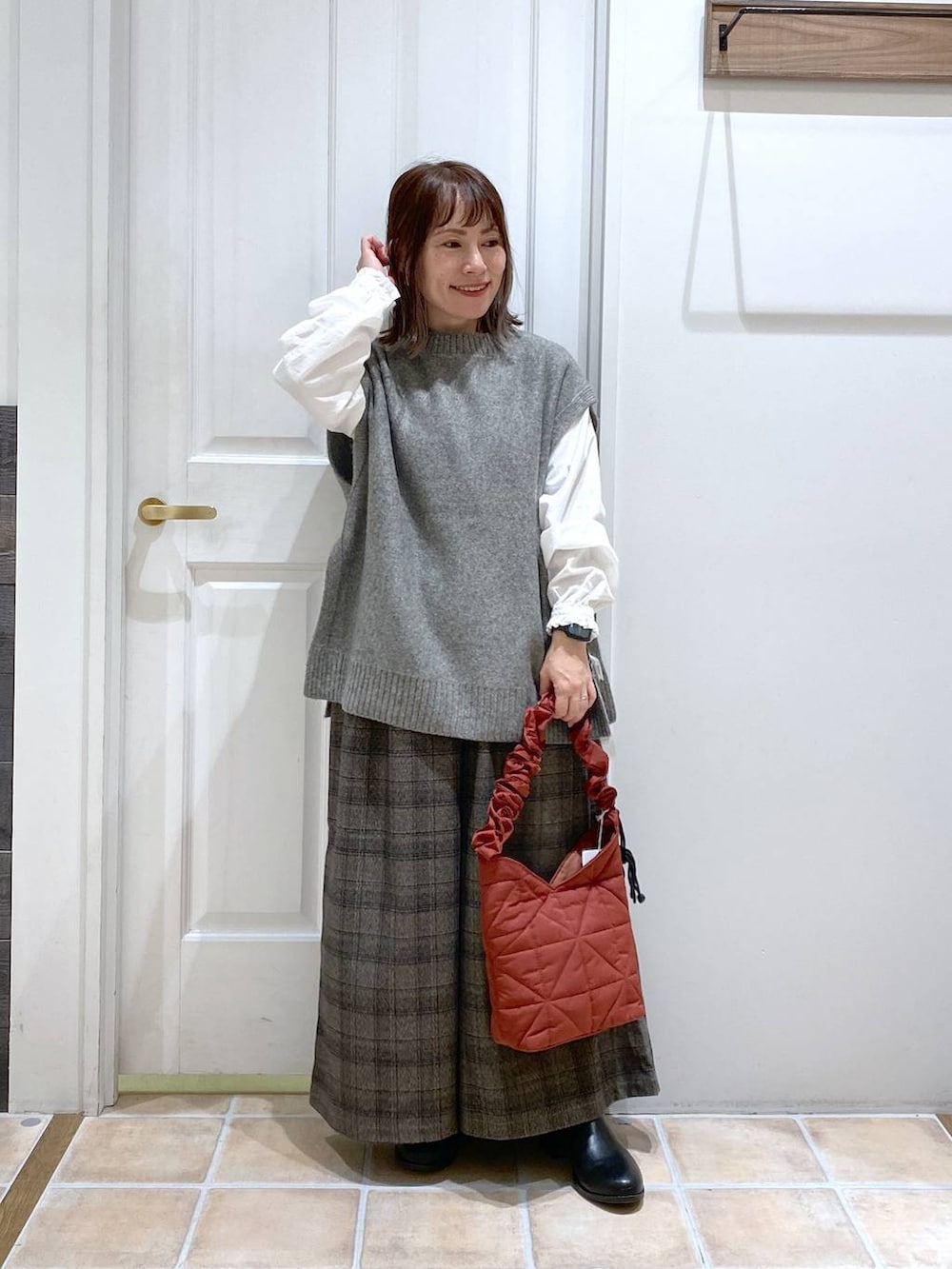 ブラック系のブーツ、その他のその他パンツ、グレー系のベストを着用したレディースの秋コーディネートの2枚目の写真