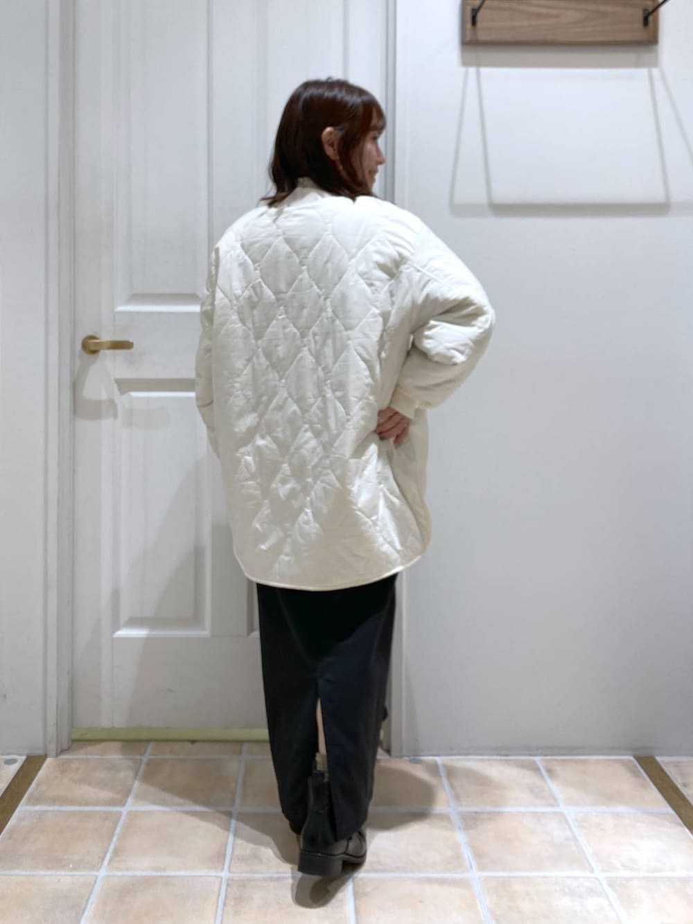 ブラック系のスカート、ホワイト系のTシャツ/カットソー、ホワイト系のノーカラーコートを着用したレディースの秋コーディネートの6枚目の写真