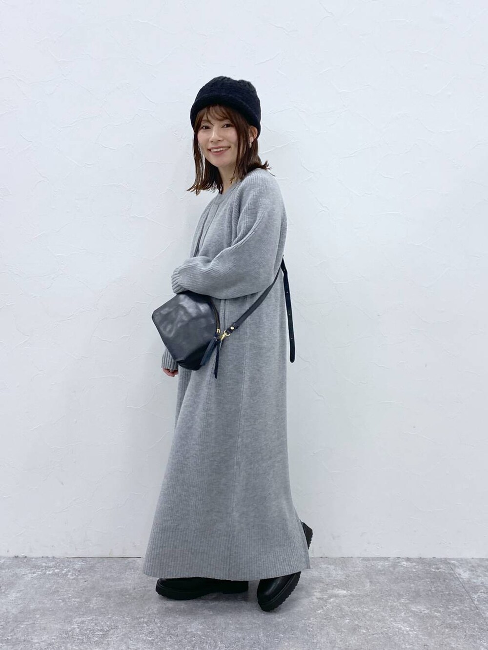 グレー系のワンピース、ブラック系のニットキャップ/ビーニーを着用したレディースの秋コーディネートの4枚目の写真