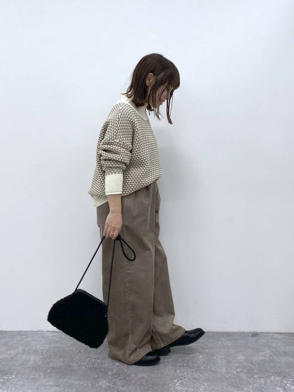 グレー系のその他パンツ、ブラック系のブーツ、ホワイト系のニット/セーターを着用したレディースの秋コーディネートの6枚目の写真