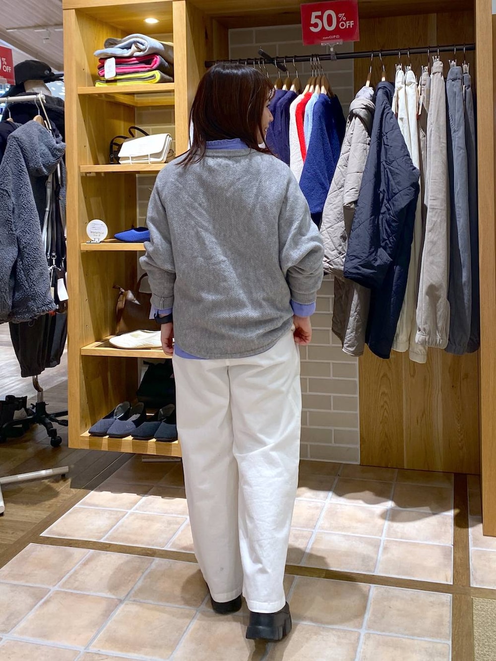 ブルー系のシャツ/ブラウス、ブラック系のブーツ、グレー系のニット/セーターを着用したレディースの冬コーディネートの5枚目の写真