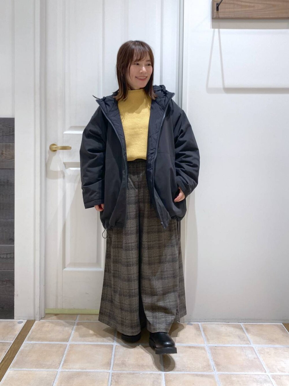 ブラック系のブーツ、イエロー系のニット/セーター、その他のその他アウターを着用したレディースの秋コーディネートの8枚目の写真
