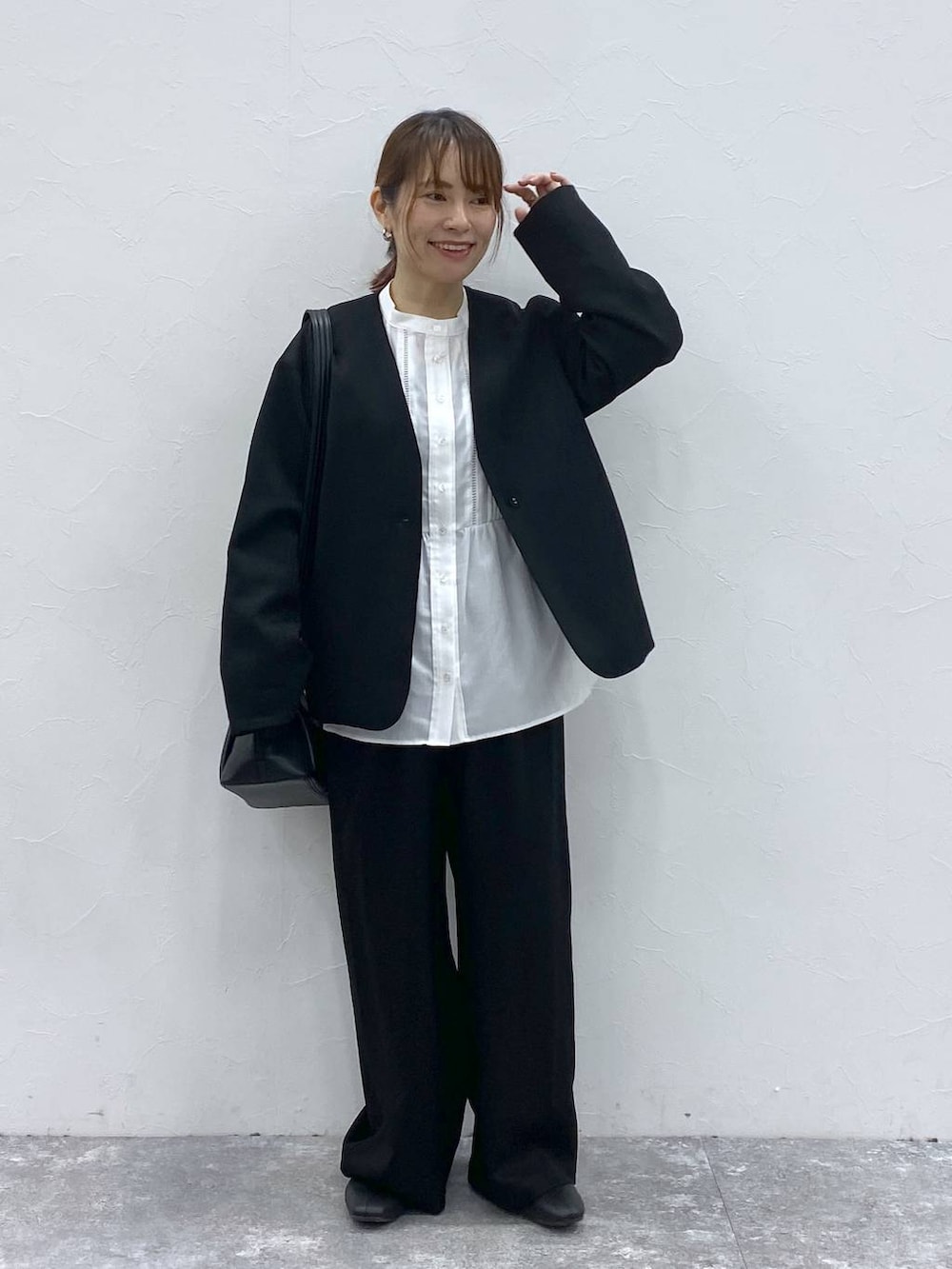 ブラック系のショルダーバッグ、ブラック系のノーカラージャケット、ホワイト系のシャツ/ブラウスを着用したレディースの冬コーディネートの3枚目の写真