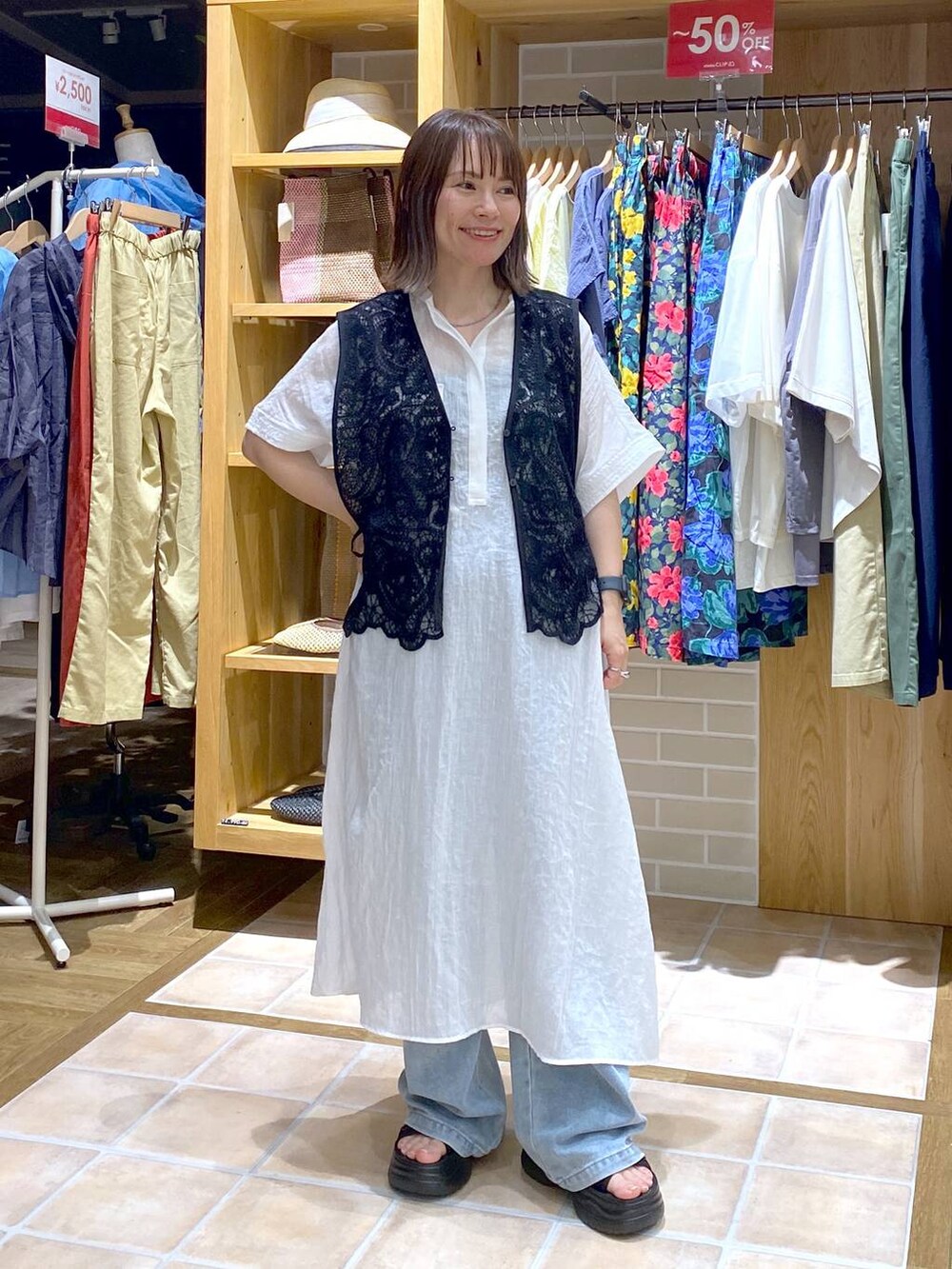 ブラック系のTシャツ/カットソー、ブラック系のサンダル、ブルー系のデニムパンツを着用したレディースの夏コーディネートの2枚目の写真