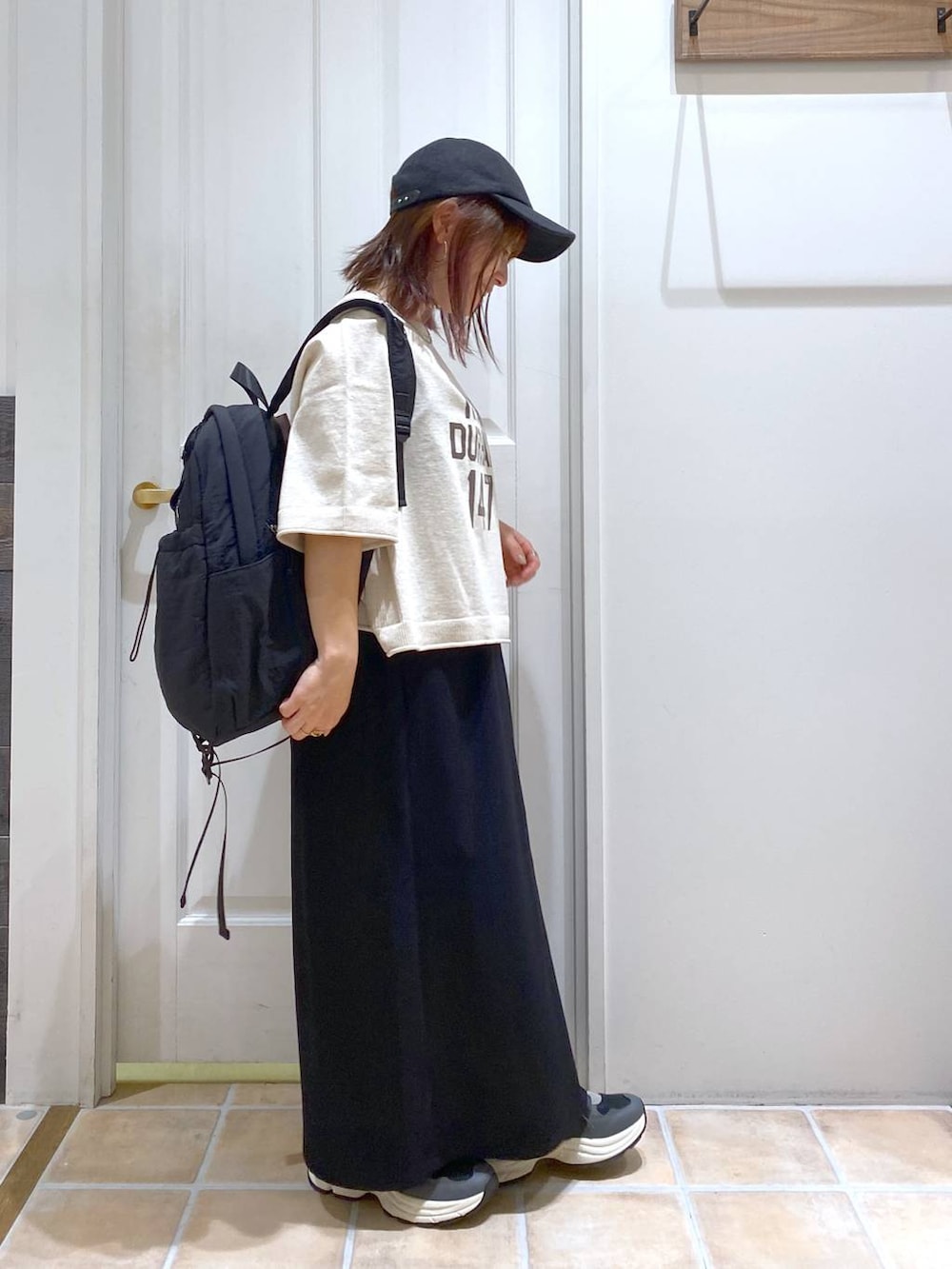 ブラック系のスカート、ブラック系のスニーカー、ベージュ系のTシャツ/カットソーを着用したレディースの秋コーディネートの5枚目の写真