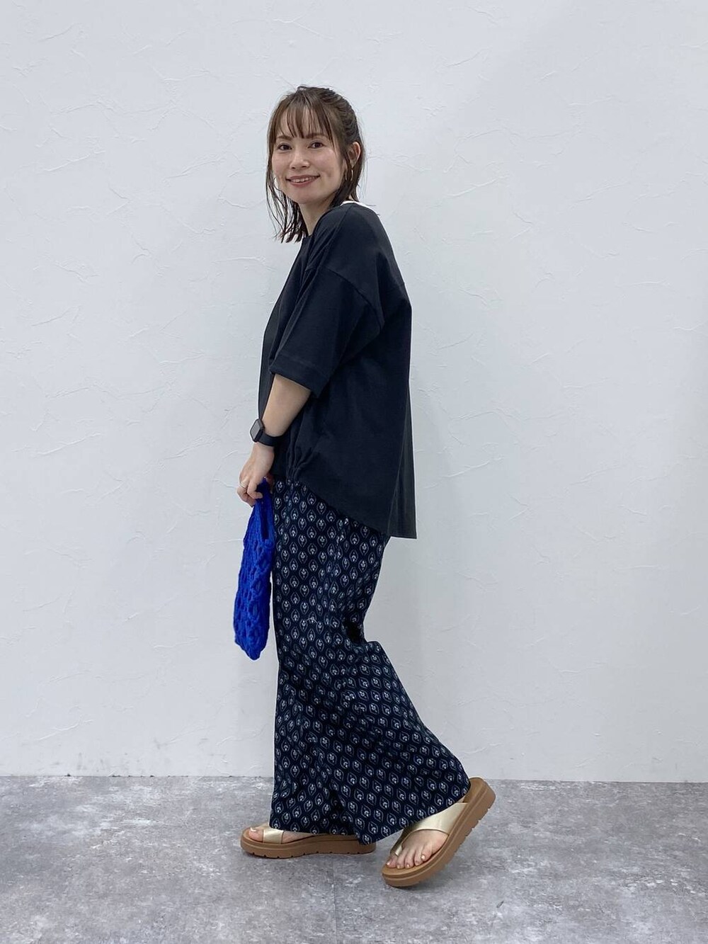 ゴールド系のサンダル、ブラック系のその他パンツ、ブラック系のTシャツ/カットソーを着用したレディースの夏コーディネートの4枚目の写真
