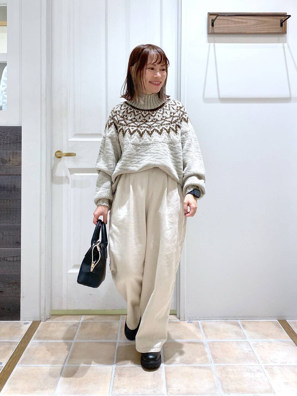 ホワイト系のその他パンツ、ブラック系のブーツ、ブラック系のショルダーバッグを着用したレディースの秋コーディネートの3枚目の写真