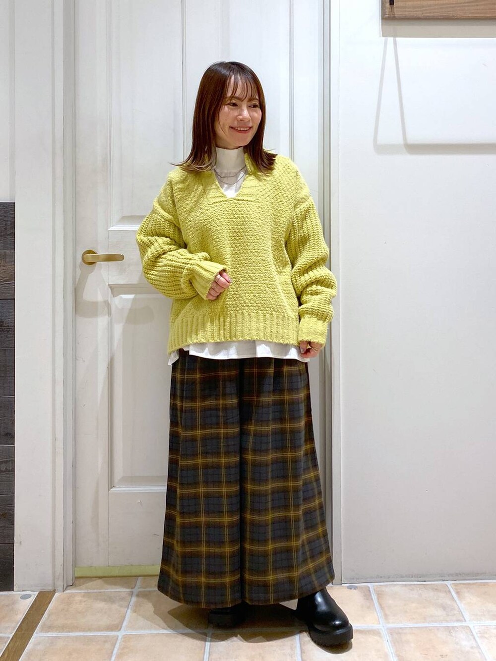 イエロー系のその他パンツ、ブラック系のブーツ、ホワイト系のシャツ/ブラウスを着用したレディースの冬コーディネートの3枚目の写真