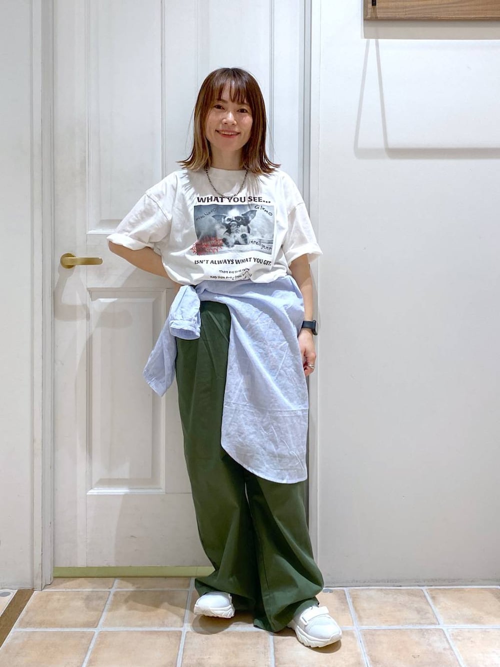 ホワイト系のスニーカー、その他のシャツ/ブラウス、グリーン系のチノパンツを着用したレディースの春コーディネートの5枚目の写真