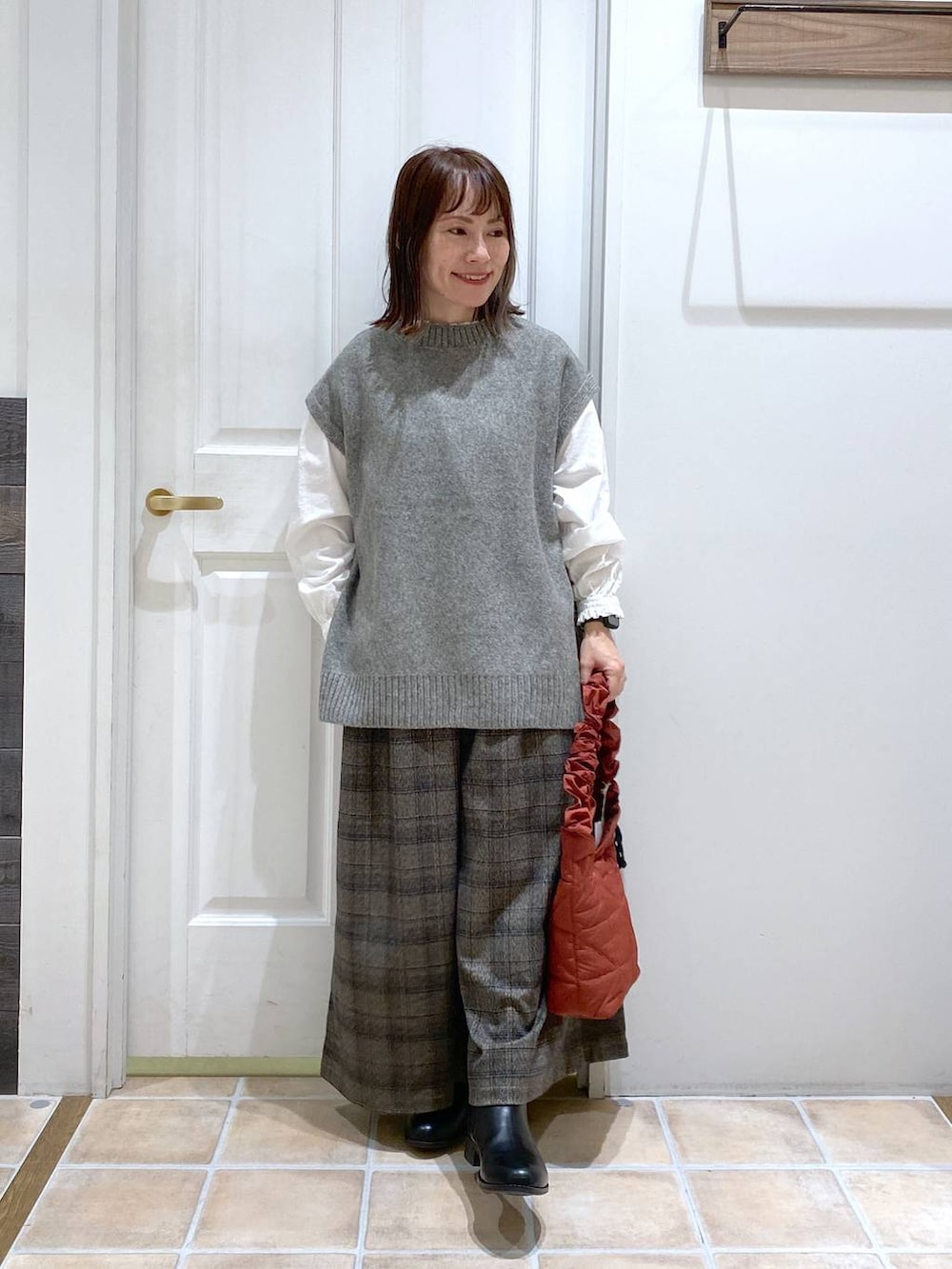 ブラック系のブーツ、その他のその他パンツ、グレー系のベストを着用したレディースの秋コーディネートの3枚目の写真