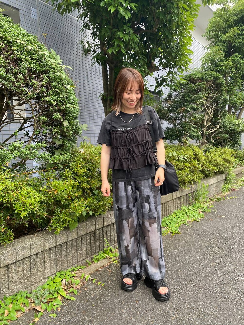 ブラック系のサンダル、ブラック系のキャミソール、グレー系のTシャツ/カットソーを着用したレディースの夏コーディネートの2枚目の写真