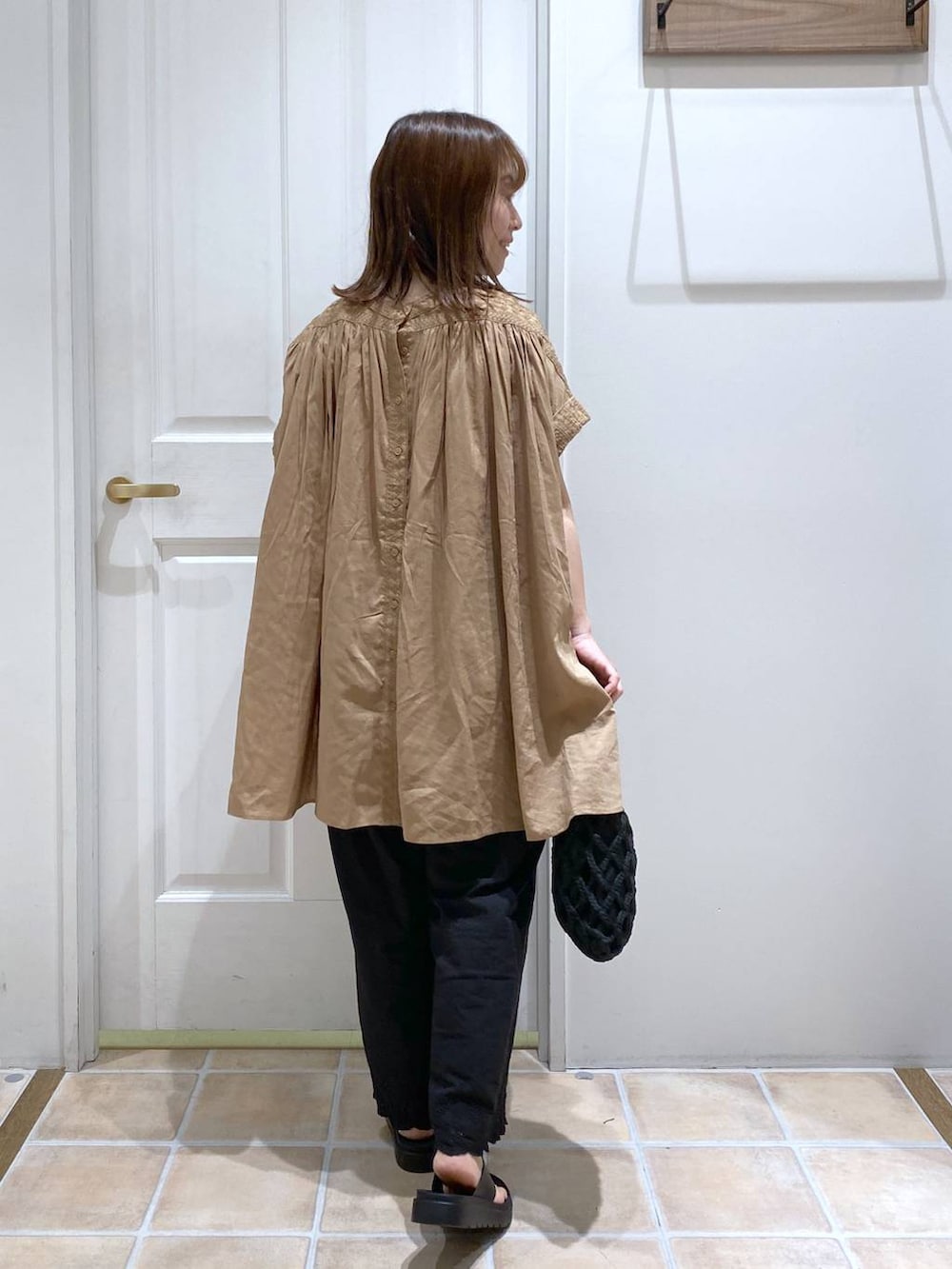 ブラウン系のタンクトップ、ブラック系のその他パンツ、ブラック系のサンダルを着用したレディースの夏コーディネートの6枚目の写真