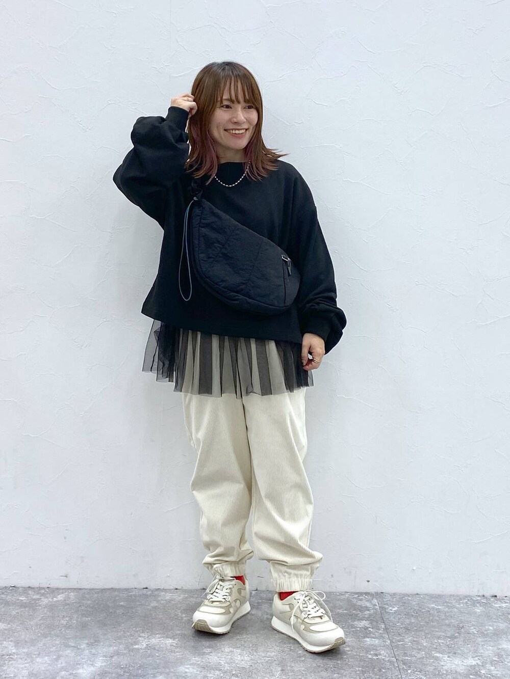 ホワイト系のスニーカー、ブラック系のショルダーバッグ、ブラック系のTシャツ/カットソーを着用したレディースの秋コーディネートの2枚目の写真