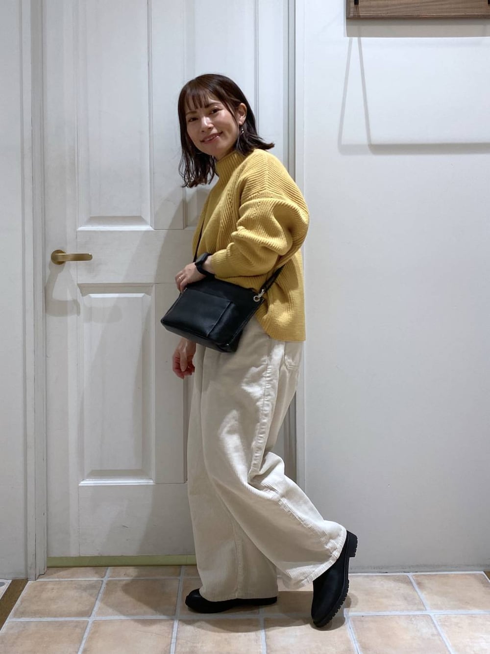 ホワイト系のその他パンツ、ブラック系のブーツ、イエロー系のニット/セーターを着用したレディースの冬コーディネートの5枚目の写真