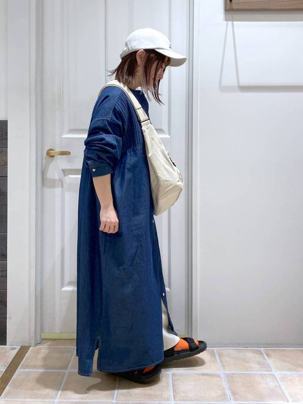 ブラック系のサンダル、ホワイト系のショルダーバッグ、ブルー系のワンピースを着用したレディースの春コーディネートの5枚目の写真