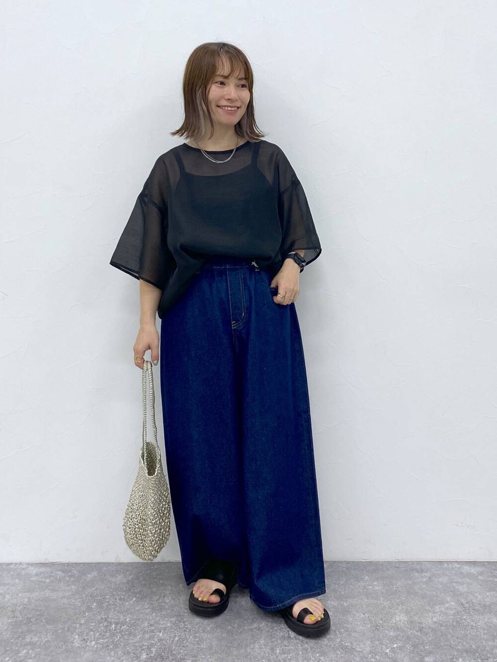 ブラック系のTシャツ/カットソー、ブラック系のサンダル、その他のハンドバッグを着用したレディースの夏コーディネートの2枚目の写真