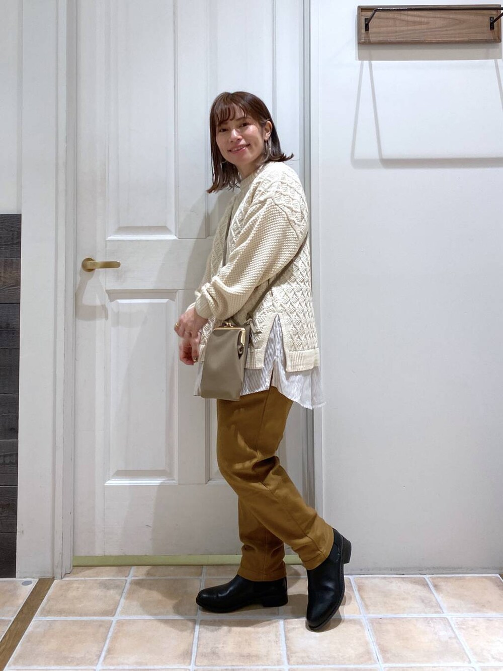 ブラック系のブーツ、イエロー系のその他パンツ、ベージュ系のニット/セーターを着用したレディースの冬コーディネートの4枚目の写真