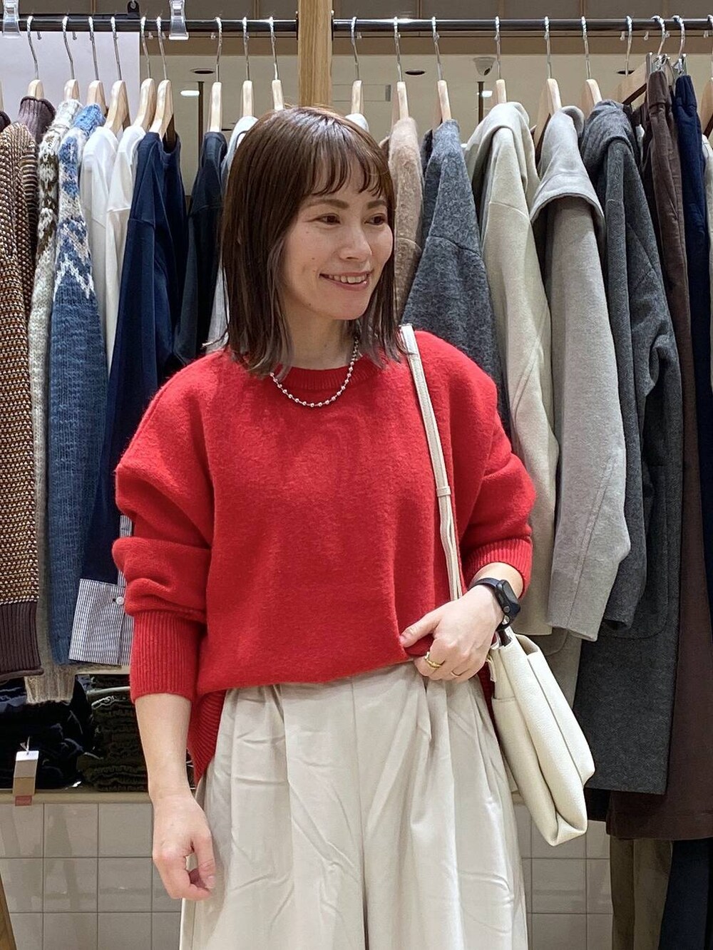 ブラック系のブーツ、ベージュ系のその他パンツ、レッド系のカーディガン/ボレロを着用したレディースの冬コーディネートの4枚目の写真