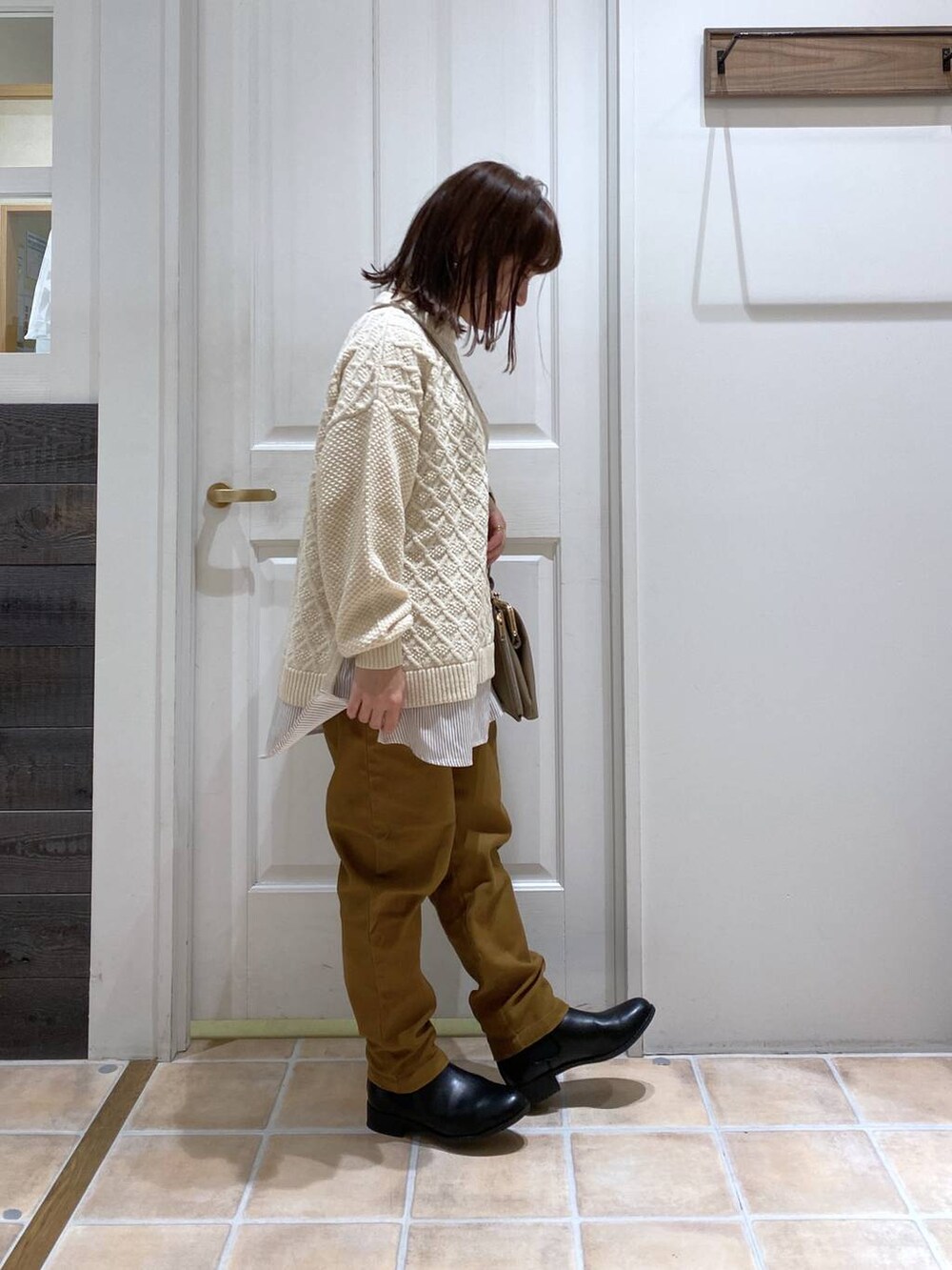 ブラック系のブーツ、イエロー系のその他パンツ、ベージュ系のニット/セーターを着用したレディースの冬コーディネートの5枚目の写真